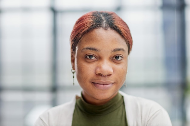 Closeup of a beautiful pensive darkskinned girl freelancer or company manager standing in the office dressed in casual clothes