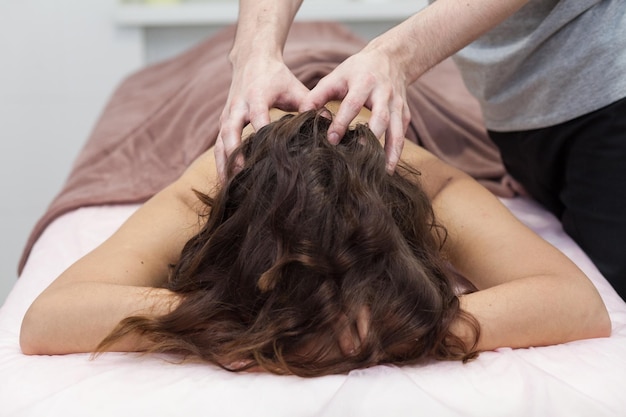 Closeup beautiful woman having deep back neck head massage View from above