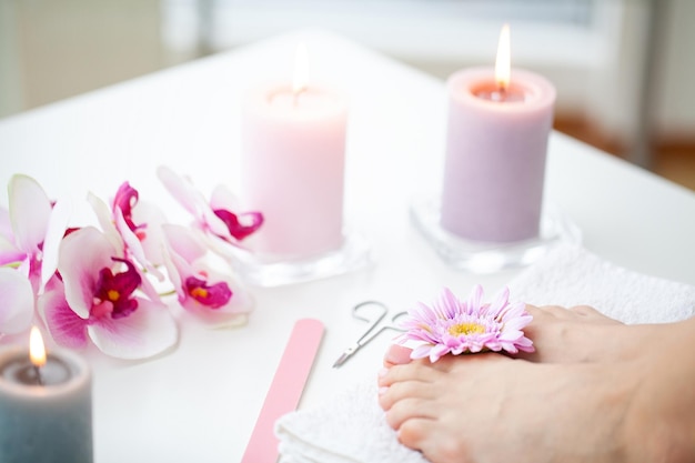 Closeup of beautiful woman legs getting pedicure at home.