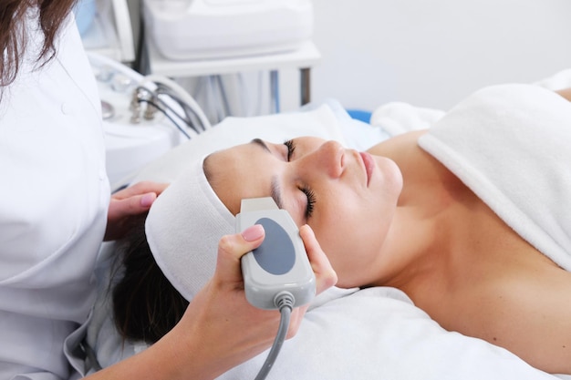 Closeup of beautiful woman's face during ultrasonic peel skin procedure at spa salon Ultrasound facial peeling Ultrasonic facial cleansing at cosmetology