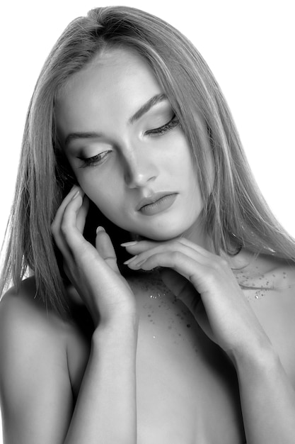 Closeup beauty shot with awesome blond model posing with professional makeup and glitter on her neck. Black and white image