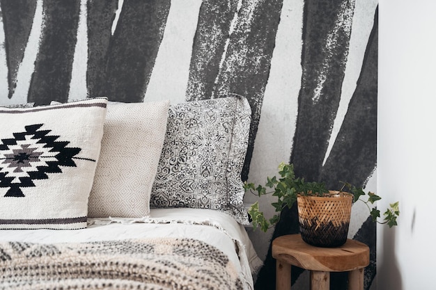 Photo closeup of bed and pillows in room with bohemian design