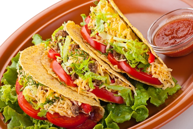 Photo closeup of beef tacos served with salad and fresh tomatoes salsa on white background