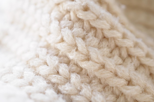 Closeup beige knitted woolen fabric texture background