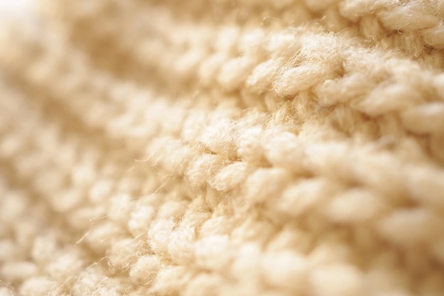 Closeup beige knitted woolen fabric texture background