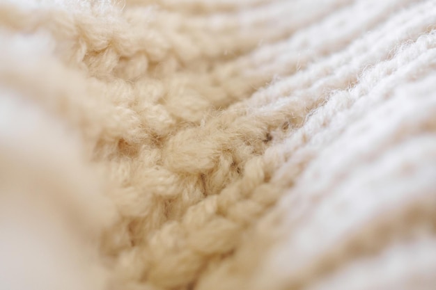 Closeup beige knitted woolen fabric texture background