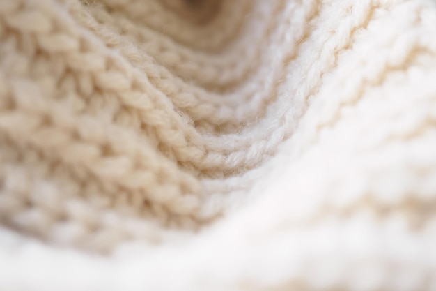 Closeup beige knitted woolen fabric texture background