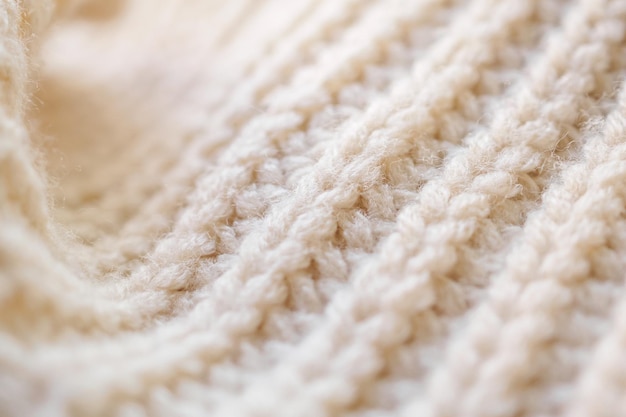 Closeup beige knitted woolen fabric texture background