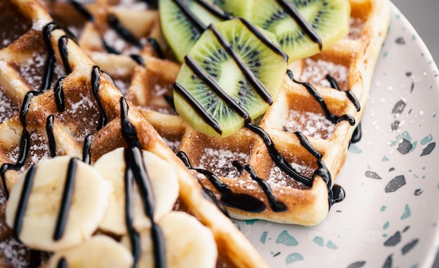 Closeup Belgian waffles with fruits covered with chocolate