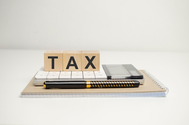 Closeup Of Bill With Calculator And Tax Text On Wooden Blocks