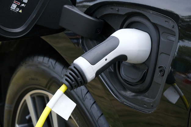 Closeup of Black Electric Car Charging In Station.