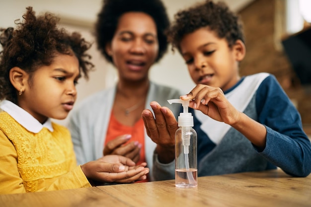 Closeup of black family disinfecting their hands at home