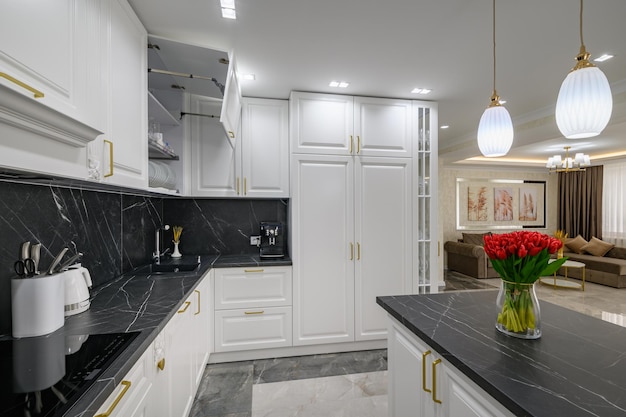 Closeup to black granite worktop of white domestic kitchen with marble floor