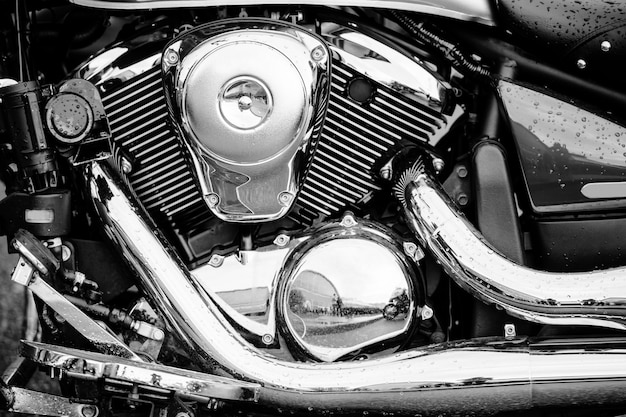 Closeup black and white photo of motorbike engine with lots of chrome details. Modern powerful performance road motorcycle  with exhaust pipes.  Chopper motor.