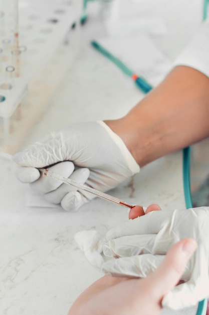 Closeup of blood sampling from finger lab technician and patient hands