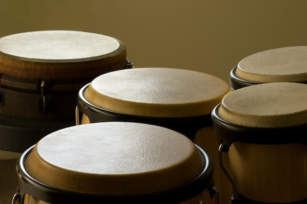 Closeup of bongo drums under the lights against a yellow background