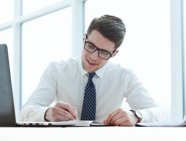 Closeup of business man writing form on clipboard at office