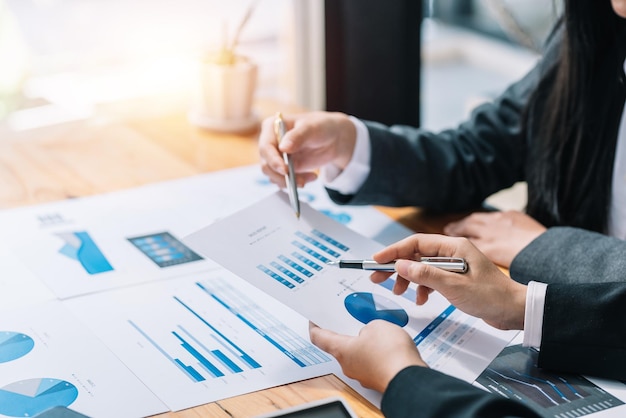 Closeup of business people analyzing chart and graph showing changes and growth on the market