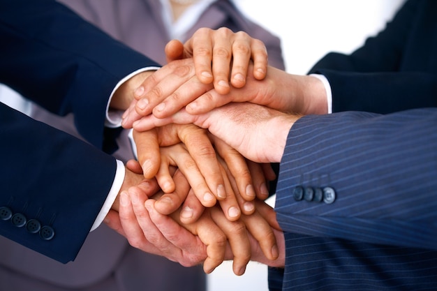 Closeup of business people's hands making a pile against a white background.