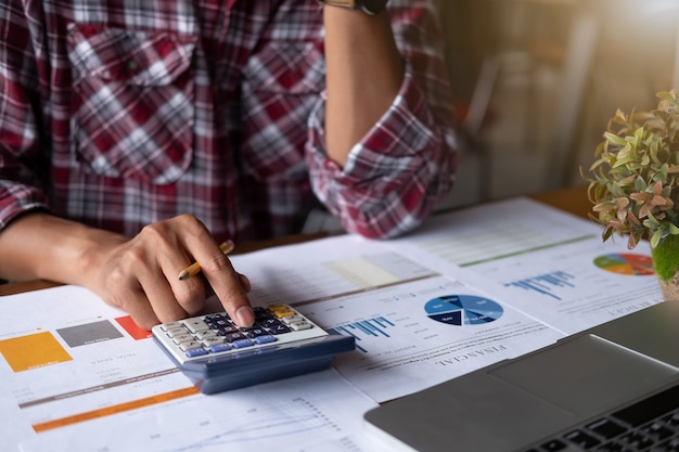 Closeup of a businessman financial specialist is working with calculator and computer 