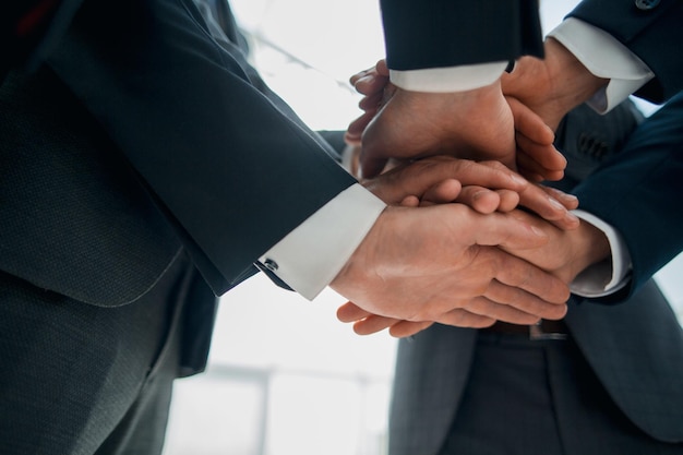 Closeup of businesspeople stacking hands in meeting concept of unity