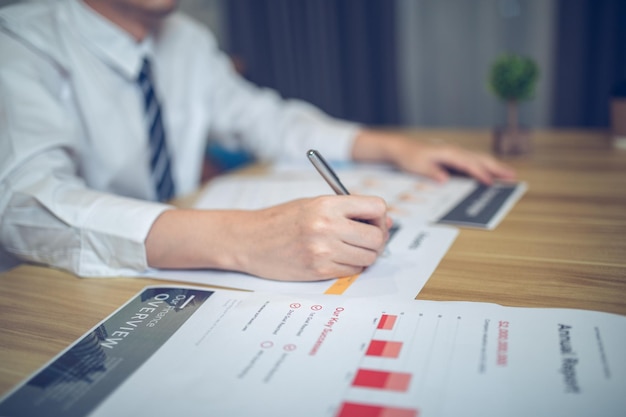 Closeup of a businessperson reviewing graphs and charts focusing on document analysis