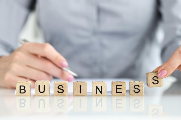 Closeup of businesswoman collected business word with wooden cubes time management marketing