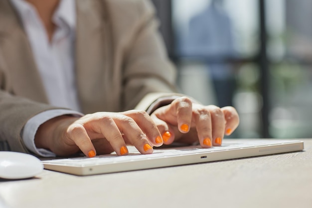 Closeup of businesswomans hand while working on her laptop