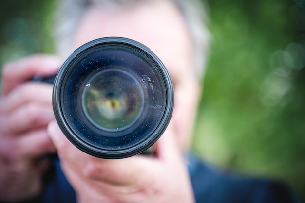 Closeup camera lens with dirty glass in the photographer's hands