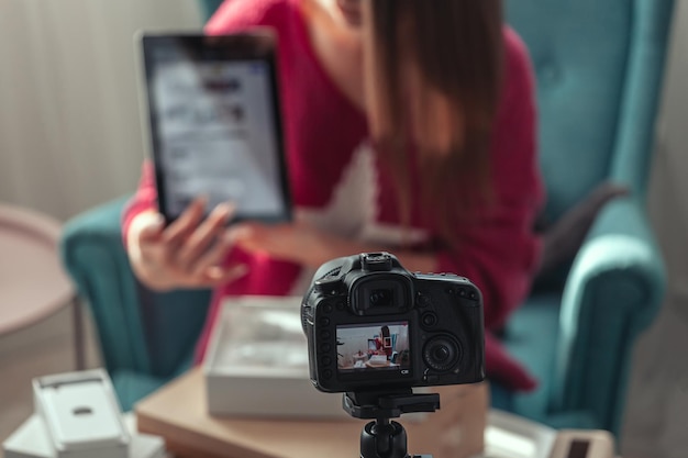 Closeup camera screen woman blogger makes video of unpacking gadgets at home