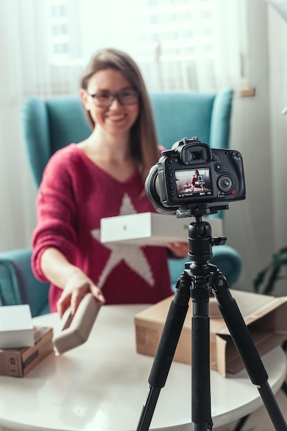 Closeup camera screen woman blogger makes video of unpacking gadgets at home