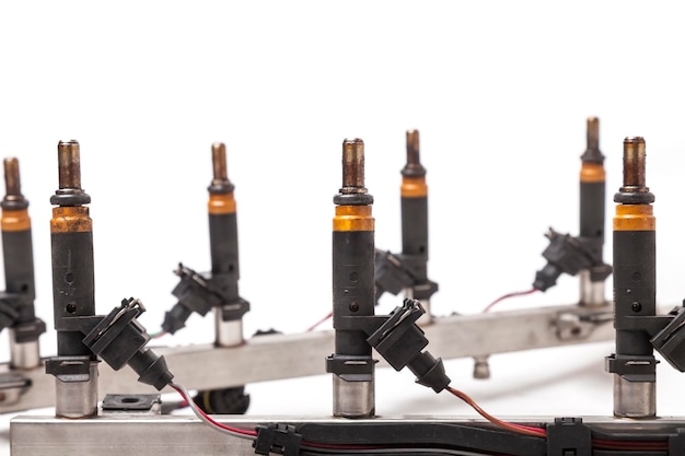 Photo closeup on a car fuel rail with injectors for supplying gasoline to eight cylinder engine on a white isolated background spare parts catalog