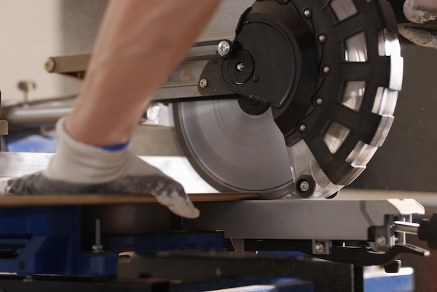 Closeup of carpenter working using special equipment for cutting board worker with modern