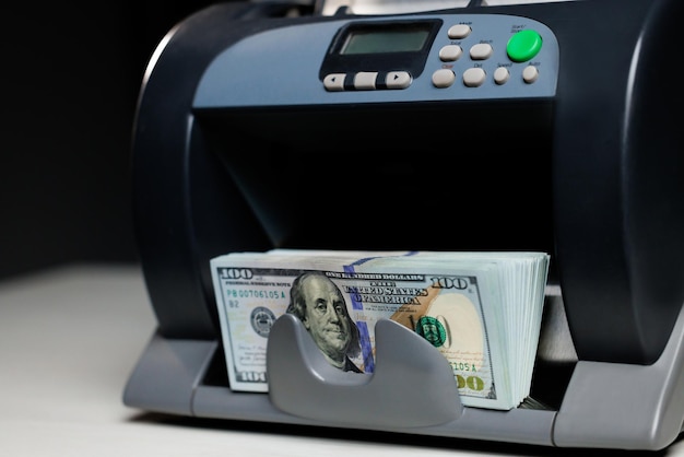 Closeup of cash counting machine counting dollar bills business accounting and commercial activity