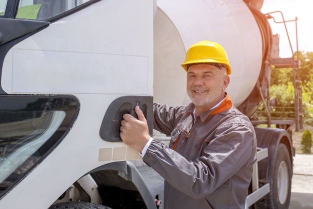 Closeup of a caucasian male engineer wearing a hard hat, opening a truck door during daylight