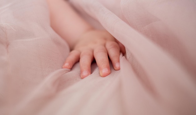 Closeup of a child's hand on a chiffon sheet