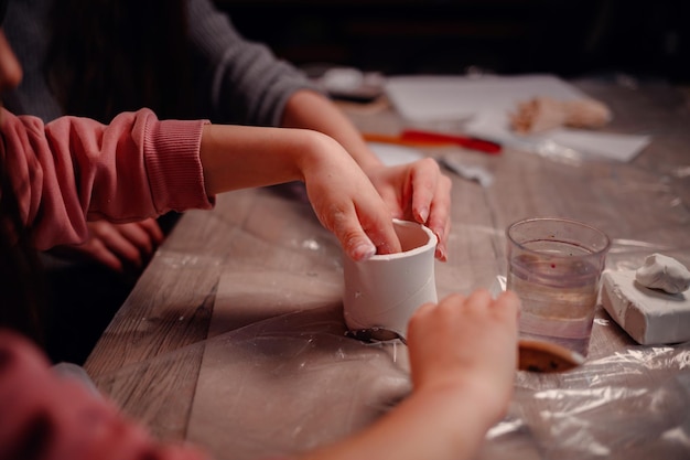 Photo closeup of a childs hands carefully assembling a clay craft symbolizing the intricate beauty of learning and creating