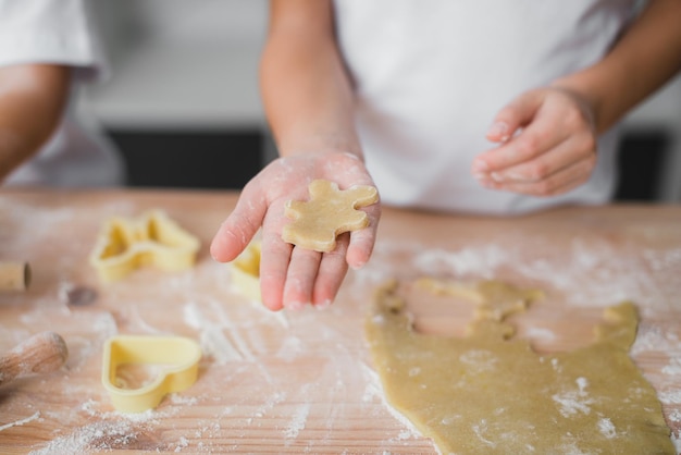 Closeup of a childs palm with a piece of raw dough biscuits resembling a bear