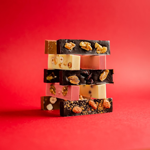 Closeup of chocolate assortment bars with different flavors on a pink background