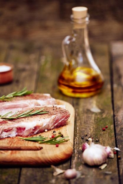 Closeup chopped raw pork meat steak on cutting board.  Vertical, selective focus.