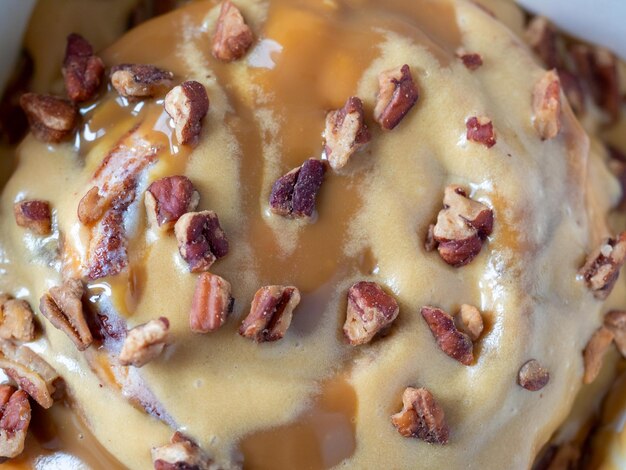 Closeup of cinnamon buns topped with caramel topping and pecans part of the dish selective focus Top view flat lay