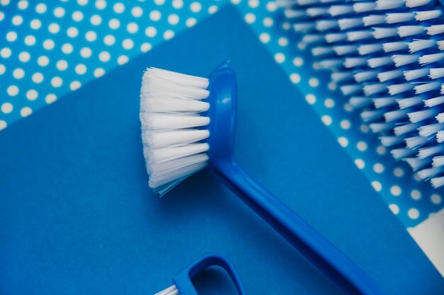 Closeup cleaning brush on a blue background A brush with a white pile and a blue handle Convenient equipment for cleaning the house