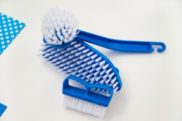 Closeup cleaning brush on a white background A brush with a white pile and a blue handle Convenient equipment for cleaning the house