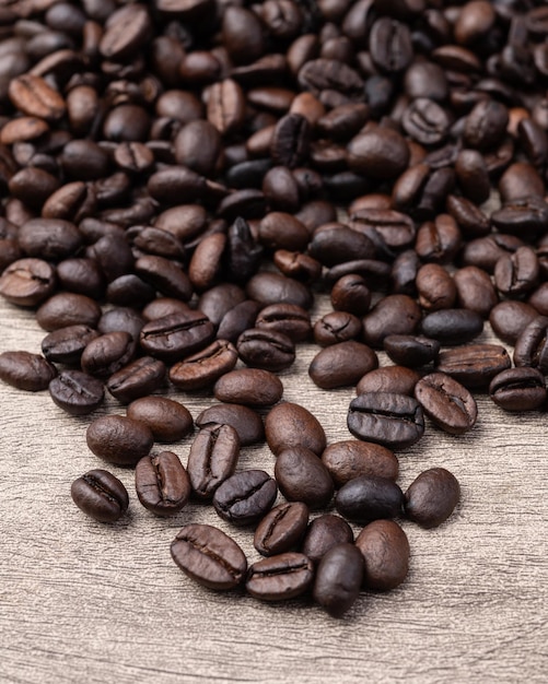 Closeup of coffee beans over rustic wooden table