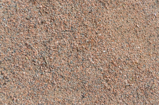 Closeup of colored small stones, sand background.