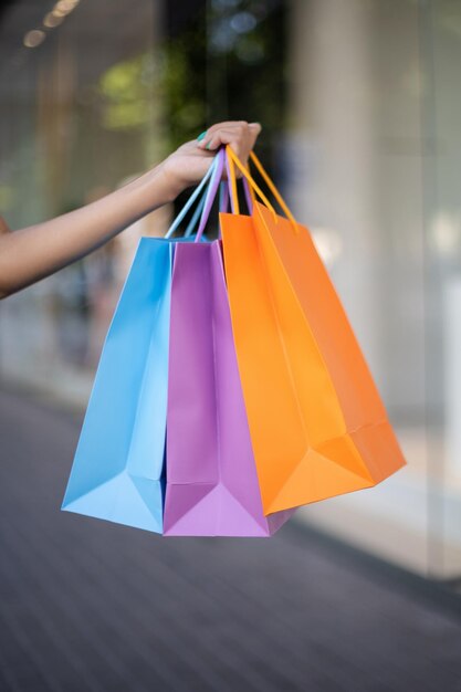 Closeup of colorful shopping bags in an African American woman's hand