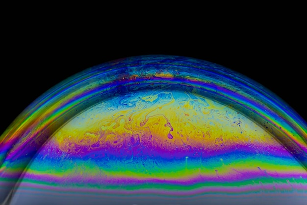 Closeup of colorful soap bubble on black background