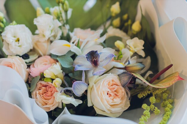 Closeup colorful spring bouquet with many different flowers jelly and white chrysanthemums burgundy red roses alstroemeria