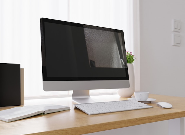 Closeup of a computer a cup of coffee a vase of flowers and more on a white desk