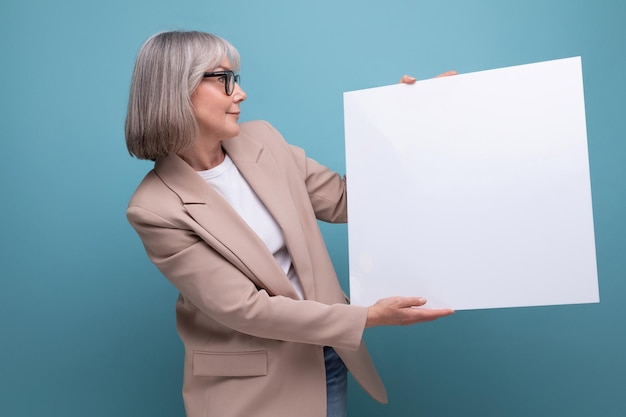 Closeup confident mature woman in a jacket demonstrates a mocap template on a bright background with